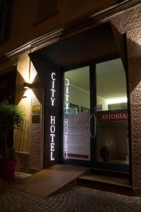 uma frente de loja com um letreiro de néon na porta em Hotel Astoria em Cremona