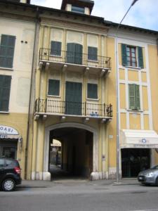 een geel gebouw met een balkon erboven bij Mansardina di Piazzale Garibaldi in Brescia