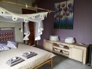 1 dormitorio con cama y mesa con almohadas en The BlueBamboo, en Le Moule