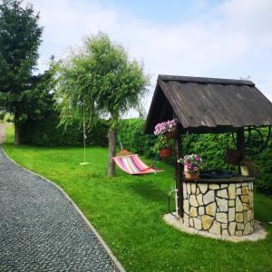 een tuin met een prieel en een hangmat in het gras bij Agronoclegi ,,Na Równi" 535-950-405 in Mchawa