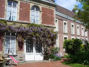 an old brick building with a wreath of purple flowers at Maison D'Hôtes Du Théâtre in Douai