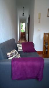 a living room with a blue couch with purple blankets at Casa del Cu bano B- Biosphere Reserve in Santa Cruz de Tenerife