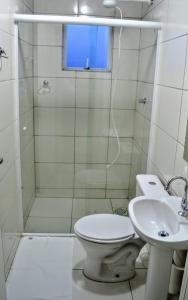 a bathroom with a shower and a toilet and a sink at Ideal Lages Hotel in Lages