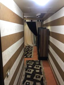 un pasillo con paredes a rayas y un pasillo con ascensor en Chalets at Pyramids Porto Sokhna by Easy Rent 2, en Ain Sokhna