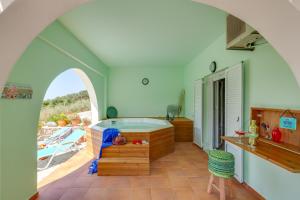 Villa Kallisti - Artemis في Kávallos: حمام مع حوض في غرفة مع قارب