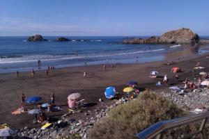 a group of people on a beach with umbrellas at Casa del Cu bano B- Biosphere Reserve in Santa Cruz de Tenerife