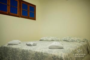 a bedroom with a bed with towels on it at Suítes Da Vila 152 in Praia do Forte