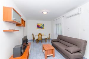- un salon avec un canapé et une table dans l'établissement Apartment Vitaic, à Supetar
