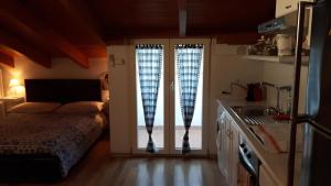 een slaapkamer met een bed en glazen schuifdeuren bij La Mansardina in Matera