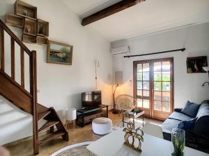 un soggiorno con un divano blu e una TV di Superbe Duplex aux Saintes terrasse plein sud 3*** a Saintes-Maries-de-la-Mer