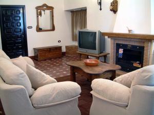Aguilar de la Frontera的住宿－Hacienda Capricho Andaluz，客厅配有两把椅子和电视
