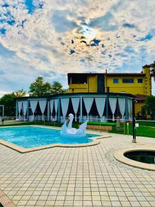 Villa Riviera Hotel Udine في Pradamano: بجعة في مسبح مع عومة بجعة