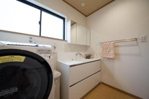 a kitchen with a washing machine and a sink at Show和の宿つちや～豊臣の隠れ茶の間～ in Nagoya