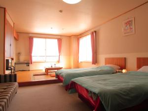 a bedroom with three beds and a living room at Hotel Moc in Myoko