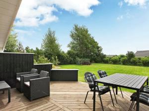 a patio with a table and chairs on a deck at 8 person holiday home in Tarm in Hemmet