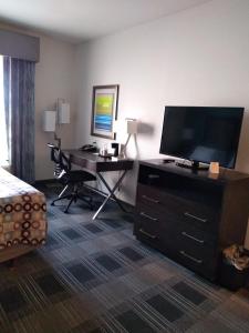 a hotel room with a desk and a television at Days Inn by Wyndham Alva in Alva