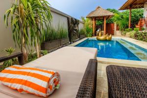 una piscina con mesa y sillas junto a una casa en Villa Agung, en Nusa Lembongan