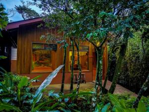 a house with a table and a chair in a garden at Monteverde Villa Lodge in Monteverde Costa Rica