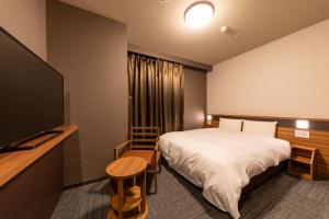 a hotel room with a bed and a flat screen tv at Dormy Inn Kawasaki Natural Hot Spring in Kawasaki +135 photos