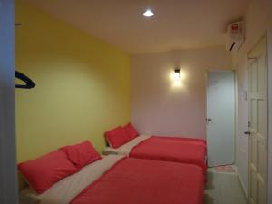 2 łóżka w pokoju z czerwoną i białą pościelą w obiekcie Famosa 2 Stay w Malakce