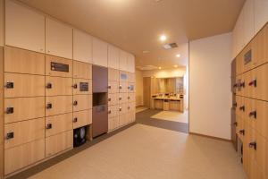 a locker room with wooden lockers and a kitchen at Dormy Inn Kawasaki Natural Hot Spring in Kawasaki