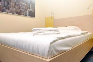 a bed with white sheets and towels on it at Best Deal Airporthotel Weeze in Weeze