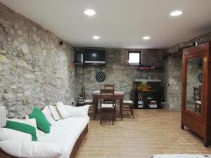 Calvi dellʼ UmbriaにあるGiardino casa Selciataの白いソファと石の壁のあるリビングルーム