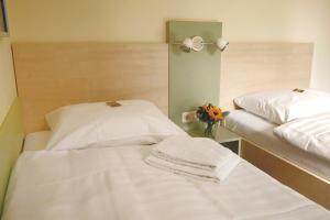 a room with two beds and a vase of flowers at Best Deal Airporthotel Weeze in Weeze