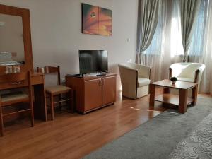 a living room with a flat screen tv and chairs at Sin-Kom Hotel Garni in Pirot