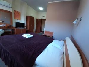 a hotel room with a bed with a purple blanket at Sin-Kom Hotel Garni in Pirot