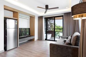 a living room with a couch and a television at Reiz - Private Residence in Chiang Mai