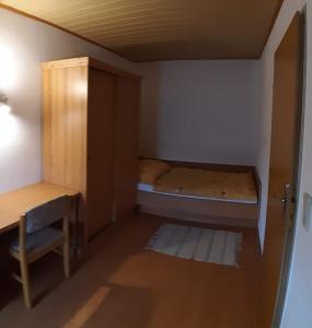 une petite chambre avec un lit et un bureau dans l'établissement Haus Königshofer, à Neusiedl am See