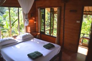 Postel nebo postele na pokoji v ubytování Khao Sok Riverside Cottages + 37 fotografií