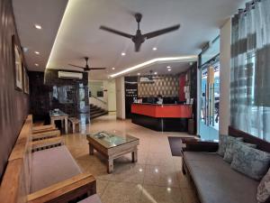Padungan Hotel في كوتشينغ: غرفة معيشة مع أريكة وطاولة