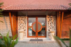 a front door of a building with a sign on it at Omorich Bali Guest House in Canggu