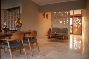 a living room with a table and chairs and a couch at Omorich Bali Guest House in Canggu