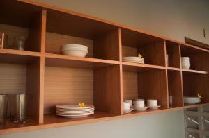 a wooden shelf with plates and dishes on it at Omorich Bali Guest House in Canggu