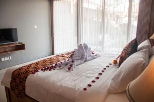a bedroom with a large bed with decorations on it at Omorich Bali Guest House in Canggu