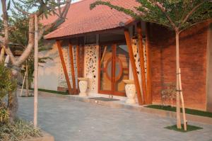a building with a door with vases in front of it at Omorich Bali Guest House in Canggu