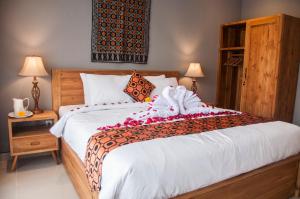 a bedroom with a large bed and two lamps at Omorich Bali Guest House in Canggu