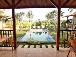 a view of a pool from a house with a porch at Omorich Bali Guest House in Canggu