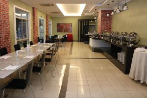 a restaurant with long tables and chairs in a room at The Jerai Hotel Sungai Petani in Sungai Petani