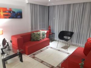 un soggiorno con divano rosso e sedia di Apartamento Playero a Cartagena de Indias
