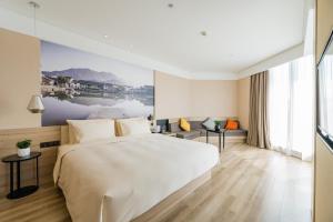Una habitación de hotel con una cama y una ventana grande. en Atour Hotel Hangzhou Future Technology City Haichuang Park, en Hangzhou
