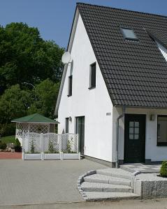 een wit huis met een zwart dak bij Ferienwohnung Am Schlosspark in Putbus