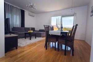sala de estar con mesa, sillas y sofá en Apartman Mila, en Kaštela