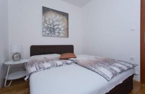 1 dormitorio con 1 cama blanca grande y mesa en Apartman Mila, en Kaštela