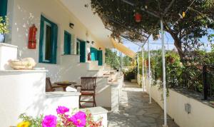 a patio with chairs and flowers on a building at Angeliki Beach Hotel in Megali Ammos