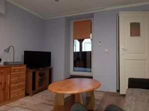a living room with a table and a television at Ferienwohnung Castelnau in Trier