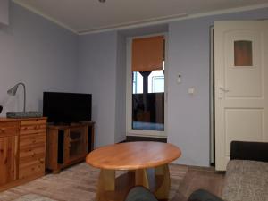 Una sala de estar con una mesa y un televisor. en Ferienwohnung Castelnau, en Trier